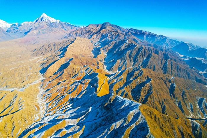 新疆阿克蘇山區雪后壯美巍峨 陽(yáng)光下群山黃白相間
